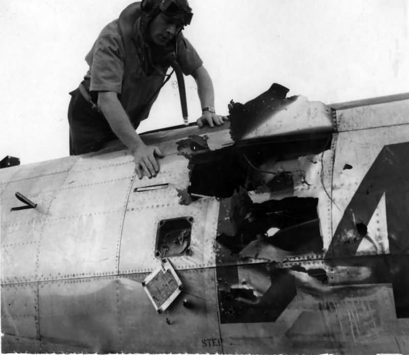 Col Ray J. Stecker of the 365th Fighter Group inspects a flak hole in his P-47 Azeville (A-7) France 1944