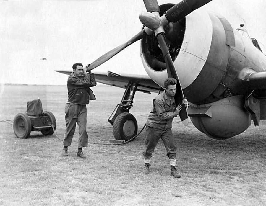 Ground crew of the 78th Fighter Group manually start the engine of a P-47 1943
