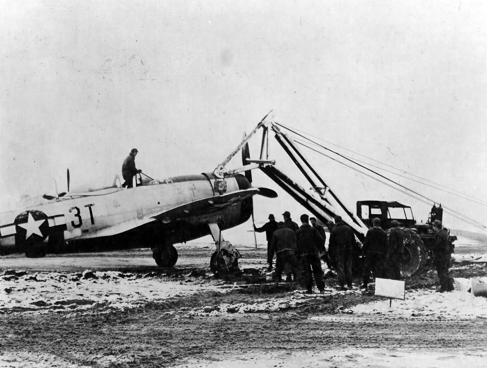 P-47D of the 22nd FS, 36th Fighter Group is extricated from the mud of Le Culot airfield A-89 Belgium December 1944