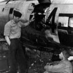 Col Stecker 365th FG inspects a flak hole in his P-47 Thunderbolt Azeville airfield A-7 France 1944