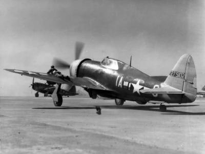 Ground crew man of the 358th FG guides a taxying P-47 Thunderbolt 42-75102