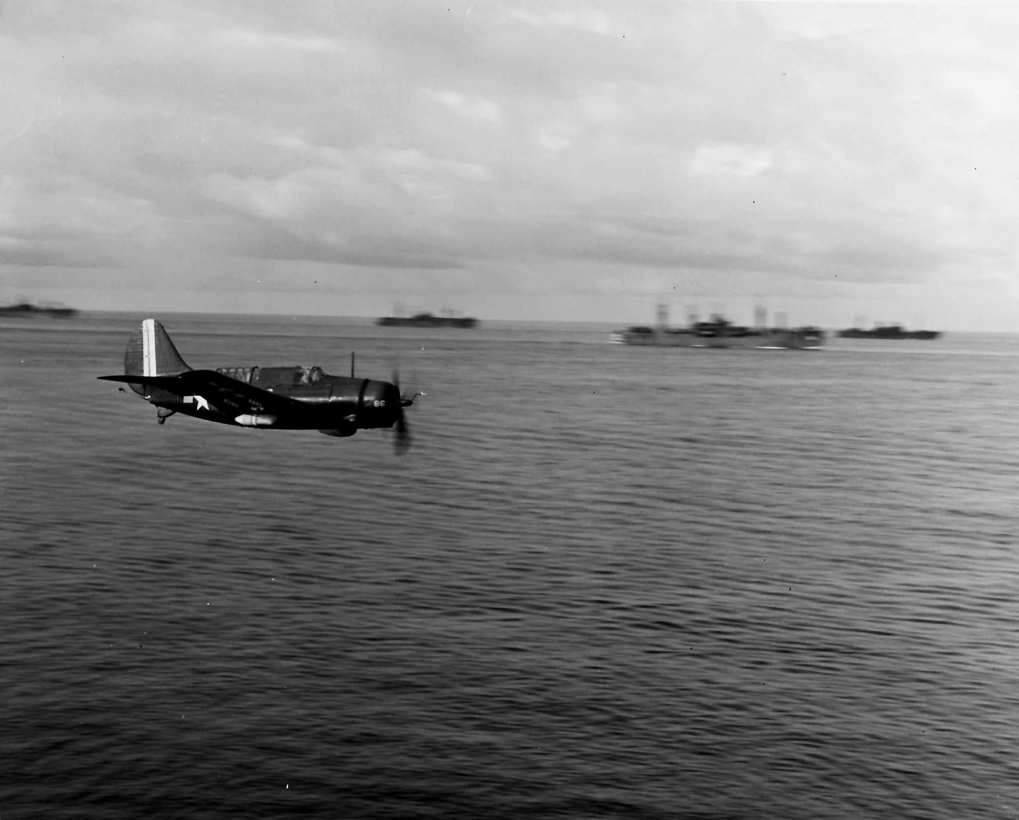 SB2C-5 Helldiver of VB-10 in flight near ships of TF-72 during operations off the China coast on 30 September 1945