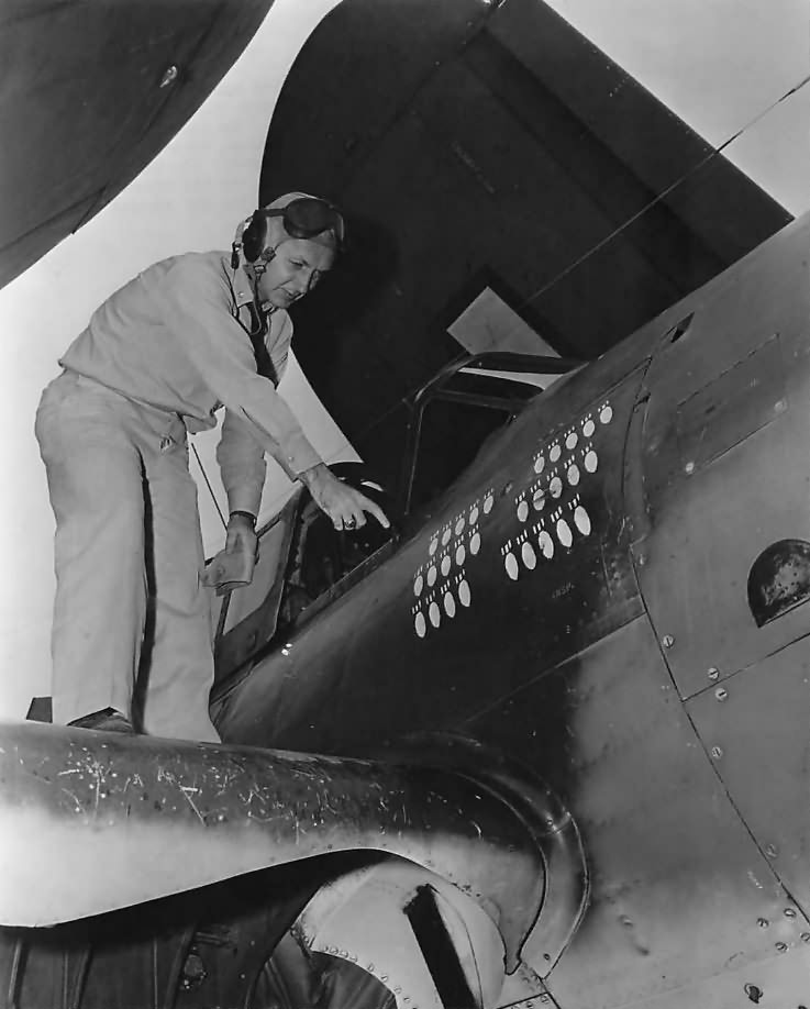 VB-1 pilot Lt Comdr Joseph Runyan by scoreboard on his SB2C 1944