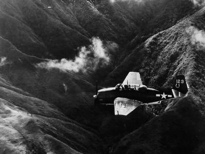 TBM #129 of the VB-7 flying over the mountains of Luzon during an aerial strike at Japanese shipping in the Philippines 1945