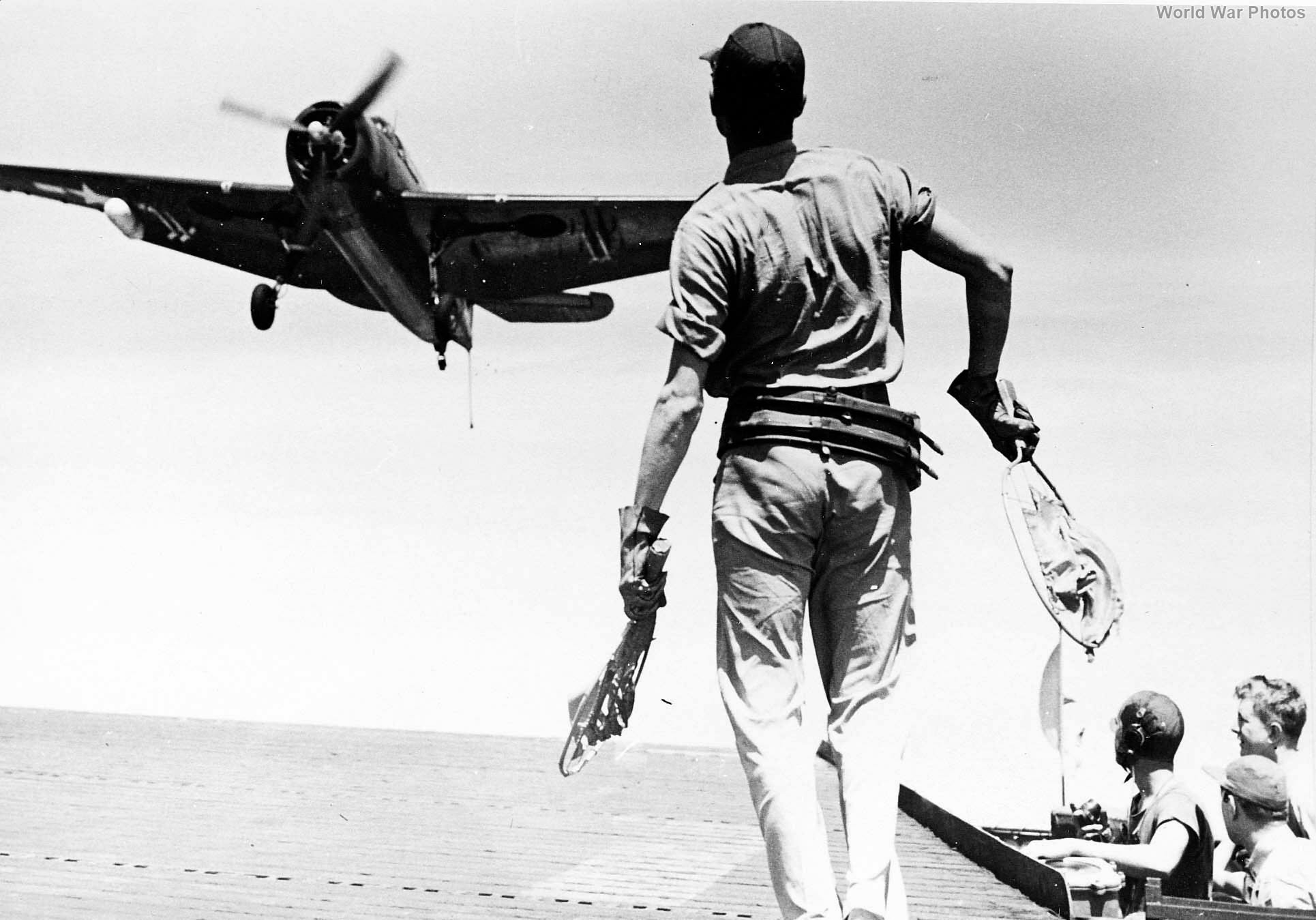 The landing signal officer waves the pilot of a TBM aboard USS Anzio 45