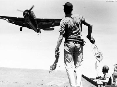 The landing signal officer waves the pilot of a TBM aboard USS Anzio 45