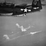 TBM of VB-7 flying from the USS Hancock over burning ships of a Japanese convoy