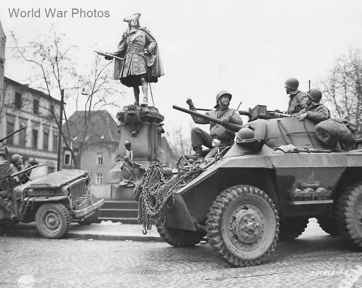 9th Army Troops in M8 passing statue in Moers Germany 1945