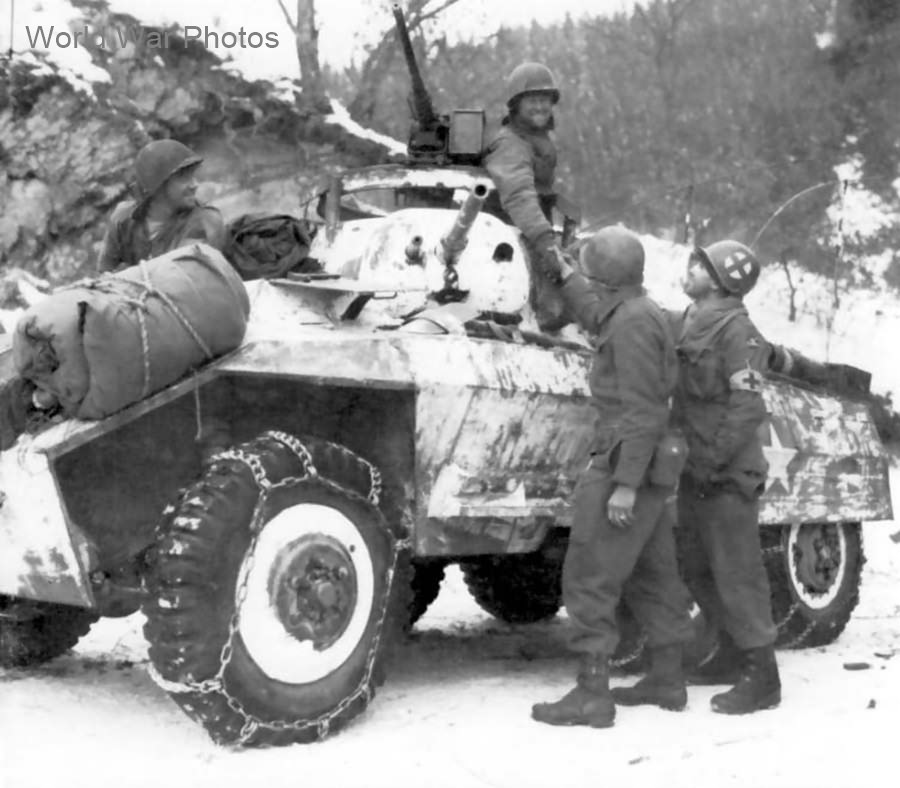 Troops of 84th Division shake hands with an M8 armored car crew