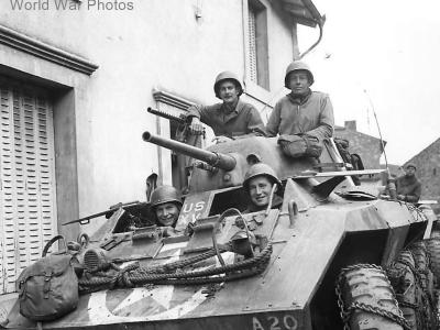 US soldiers in M8 of the 106th Cavalry Regiment in small French village