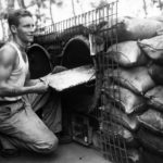 Marine cook baking in makeshift oven on Cape Gloucester