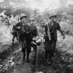 Marines carry wounded comrade for aid on Cape Gloucester