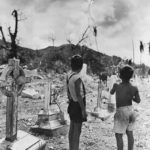 Chamorro boys fly kite in wrecked Pigo Cemetery on Guam