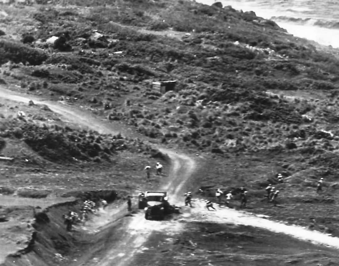 US plane comes low for strafing Japanese defenders on Iwo Jima scatter in all directions