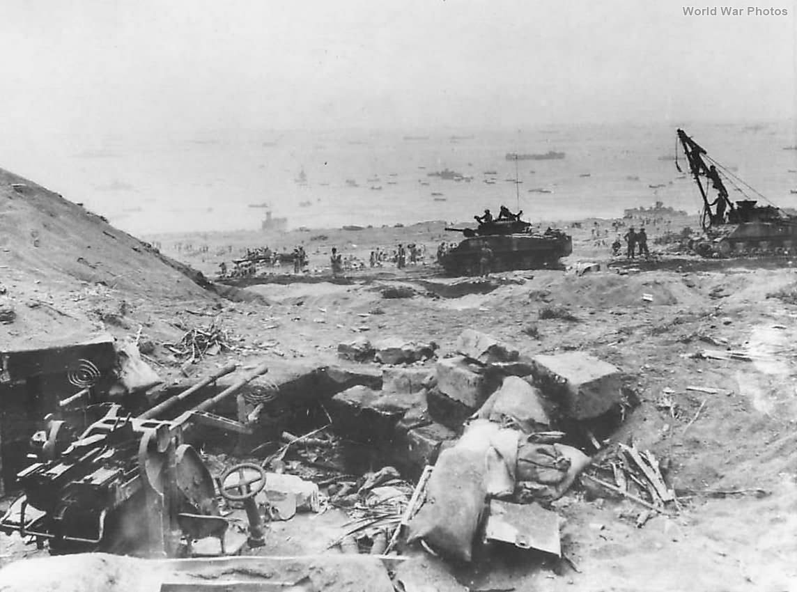 Troops on Iwo Jima Beach viewed over KO’d Japanese gun position