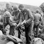 Marine patrol studies Japanese maps on Iwo Jima