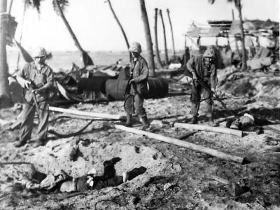 4th Division Marines check Japanese dead at Roi Airfield