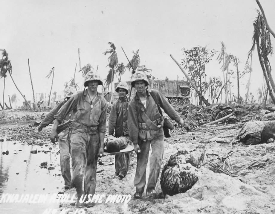 Corpsmen carry a wounded Marine on a stretcher
