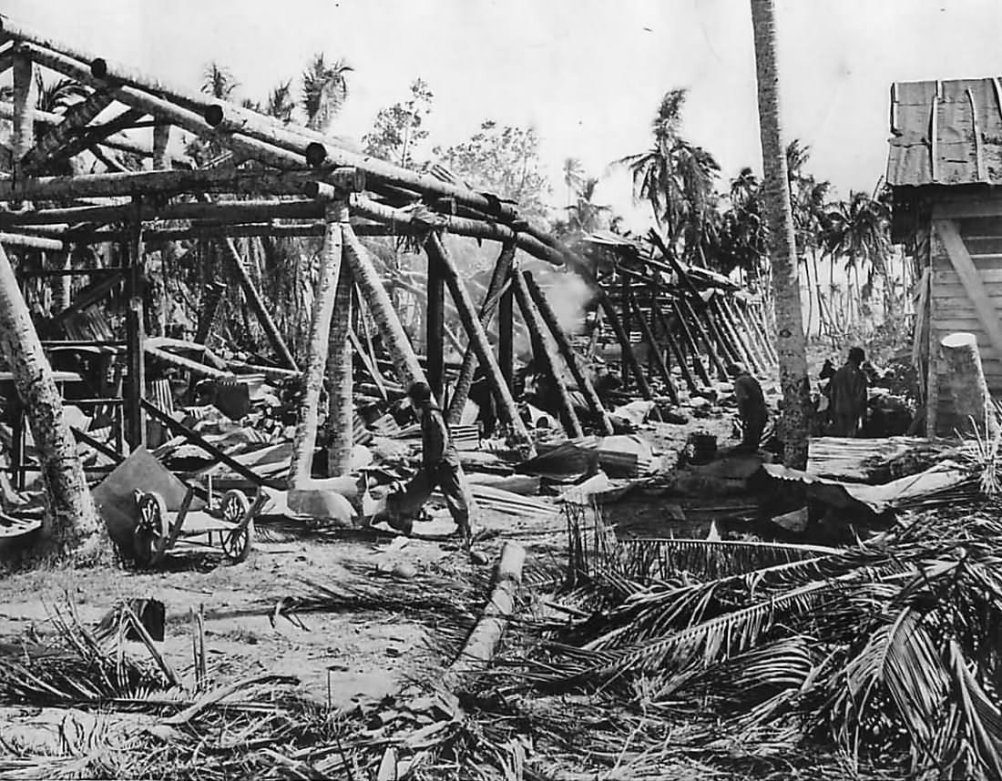 US Troops move thru ruins of Japanese warehouse on Makin
