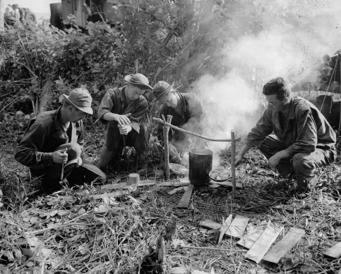 US Soldiers Heat Rations over Fire near Buna, New Guinea