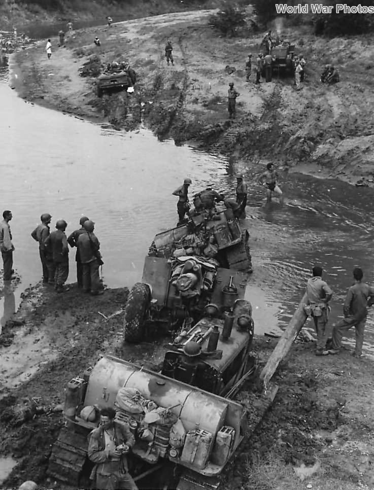 Troops use tractors to free 155mm howitzer mired in mud on Luzon