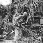 Troops inspect knocked out Japanese tractor on Luzon