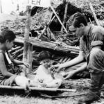 US Soldier gives child candy at Navy Evacuation Center on Leyte 1944