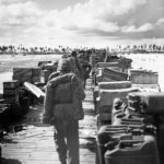 USMC reinforcements march down pier
