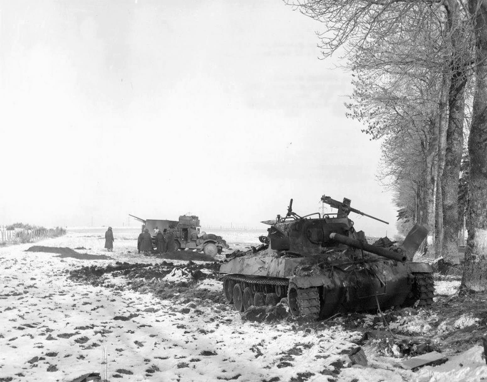 Destroyed M18 and M15 Halftrack in the background. Bastogne, December 29, 1944