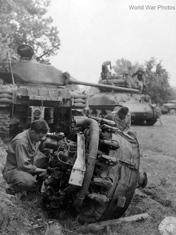 U.S. tanker performing maintenance on a M4A1(76) Sherman tank