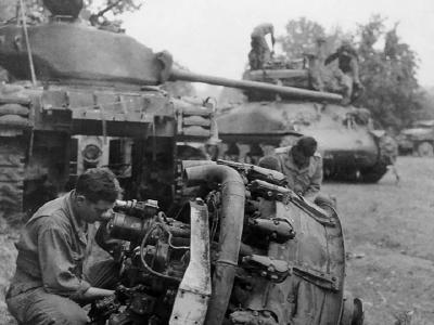 U.S. tanker performing maintenance on a M4A1(76) Sherman tank