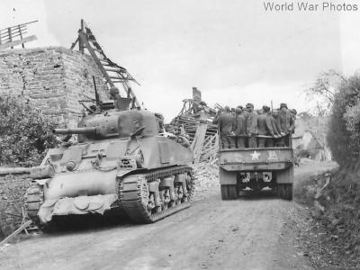M4 passes trukload of German prisoners in Normandy
