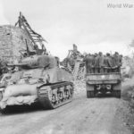 M4 passes trukload of German prisoners in Normandy