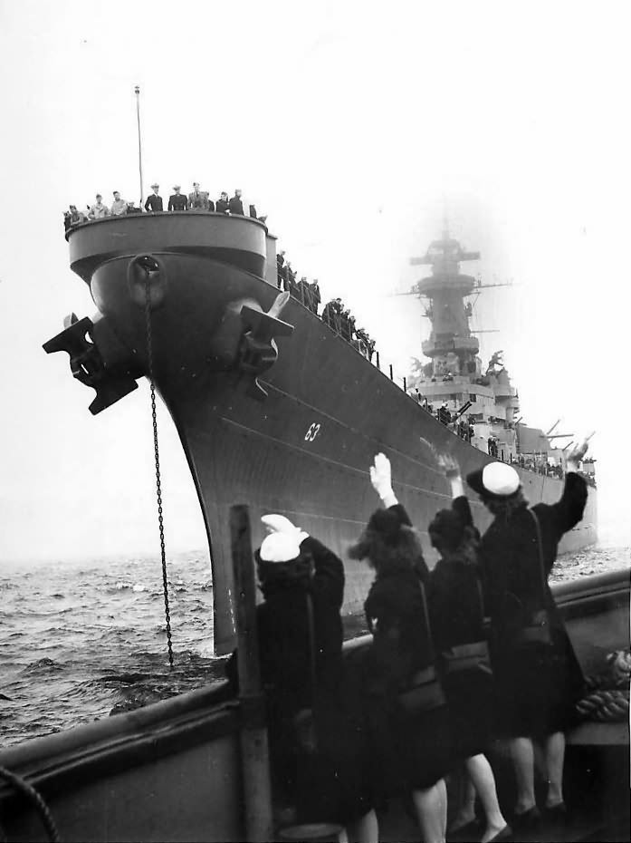 Girls wave as returning USS Missouri (BB-63) docks at Pier 90 in New York 1945