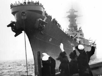 Girls wave as returning USS Missouri (BB-63) docks at Pier 90 in New York 1945