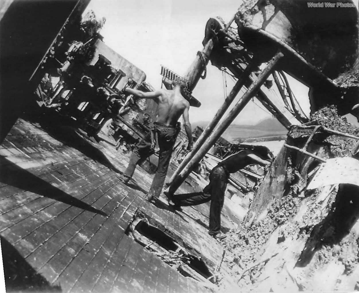 Navy personnel on tilted deck of USS Oklahoma