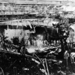 Wreckage on hangar deck escort carrier USS Sangamon after a kamikaze attack