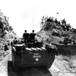 Troops of 96th Division pause at the pass leading to Chatan village Okinawa