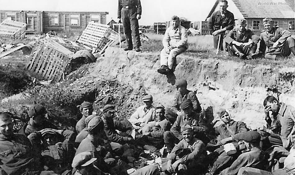Battered Russian POWs gathered in ditch by Wehrmacht captors
